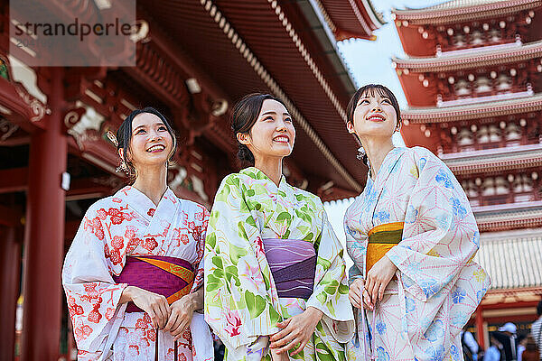 Japanese friends wearing yukata visiting traditional temple in Tokyo