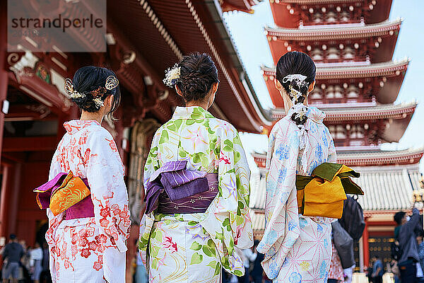 Japanese friends wearing yukata visiting traditional temple in Tokyo