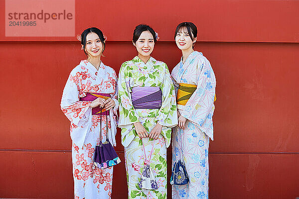 Japanese friends wearing yukata visiting traditional temple in Tokyo