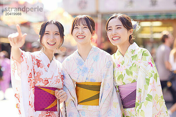 Japanese friends wearing yukata visiting traditional temple in Tokyo