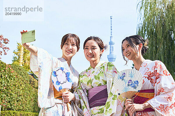 Japanese friends wearing yukata visiting traditional area in Tokyo