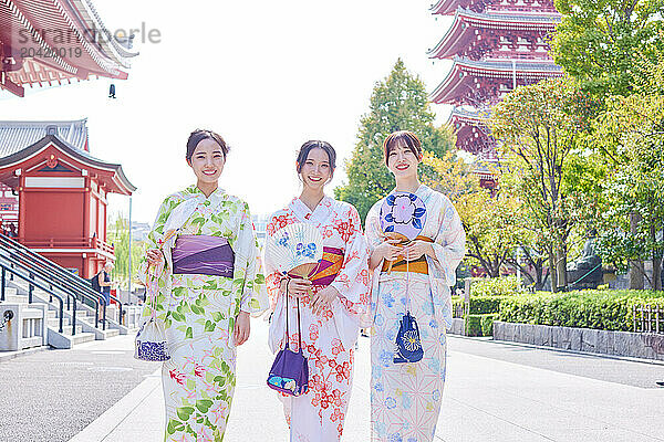 Japanese friends wearing yukata visiting traditional temple in Tokyo