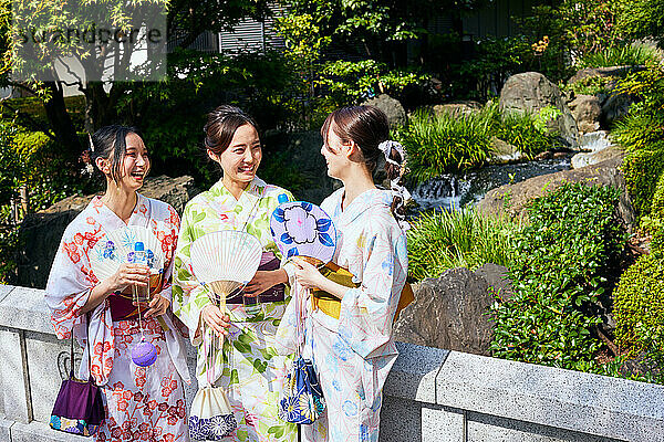 Japanese friends wearing yukata visiting traditional temple in Tokyo