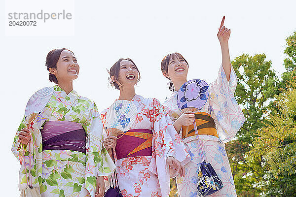 Japanese friends wearing yukata visiting traditional temple in Tokyo