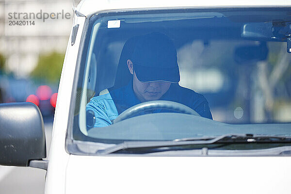 Japanese delivery man sitting in the driver seat