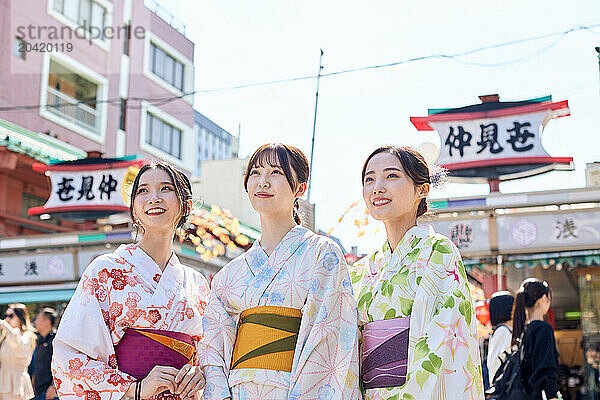 Japanese friends wearing yukata visiting traditional temple in Tokyo