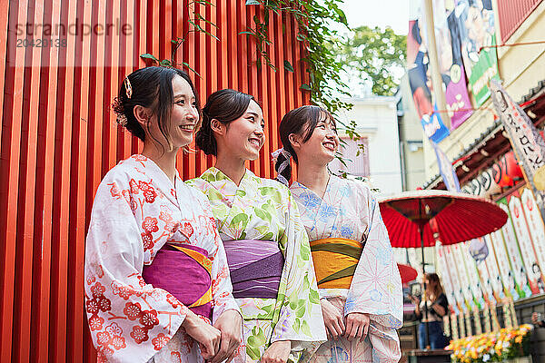 Japanese friends wearing yukata visiting traditional area in Tokyo