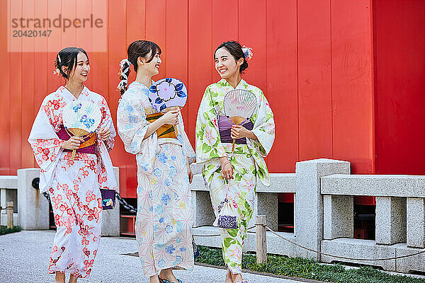 Japanese friends wearing yukata visiting traditional temple in Tokyo