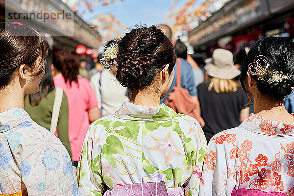 Japanese friends wearing yukata visiting traditional temple in Tokyo