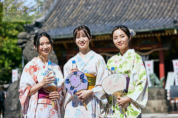 Japanese friends wearing yukata visiting traditional temple in Tokyo