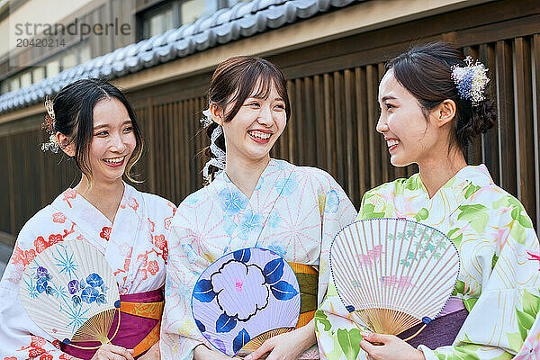 Japanese friends wearing yukata visiting traditional area in Tokyo