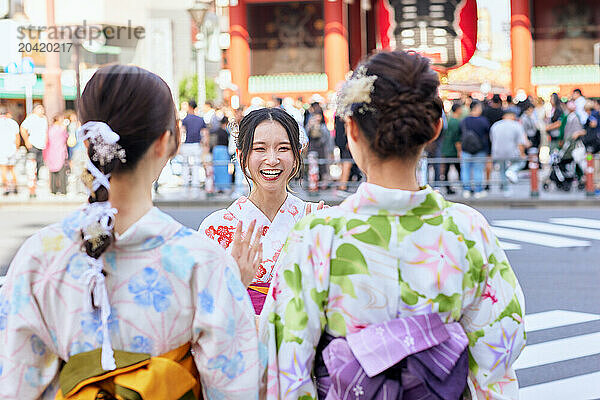 Japanese friends wearing yukata visiting traditional temple in Tokyo