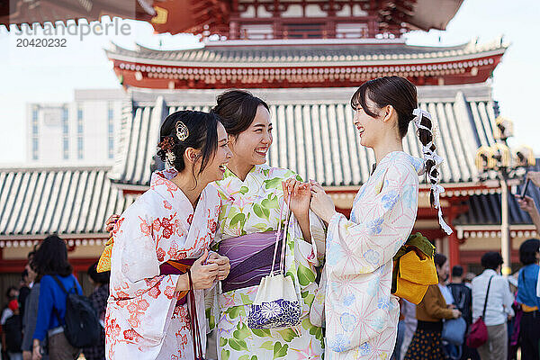 Japanese friends wearing yukata visiting traditional temple in Tokyo