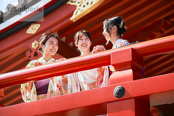 Japanese friends wearing yukata visiting traditional temple in Tokyo