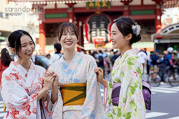 Japanese friends wearing yukata visiting traditional temple in Tokyo