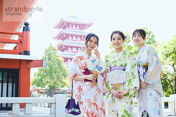 Japanese friends wearing yukata visiting traditional temple in Tokyo