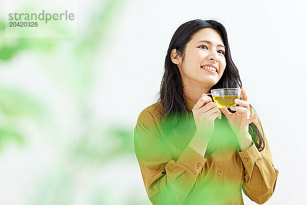 Japanese woman drinking tea against white background