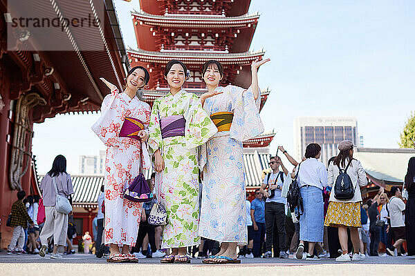 Japanese friends wearing yukata visiting traditional temple in Tokyo