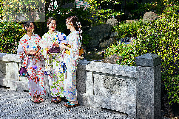 Japanese friends wearing yukata visiting traditional temple in Tokyo