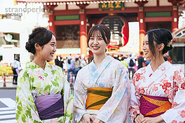 Japanese friends wearing yukata visiting traditional temple in Tokyo