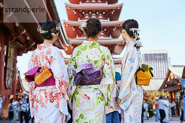 Japanese friends wearing yukata visiting traditional temple in Tokyo