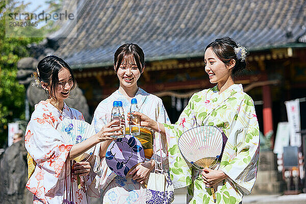 Japanese friends wearing yukata visiting traditional temple in Tokyo