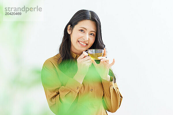 Japanese woman drinking tea against white background