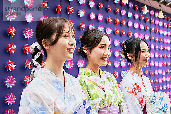 Japanese friends wearing yukata visiting traditional area in Tokyo