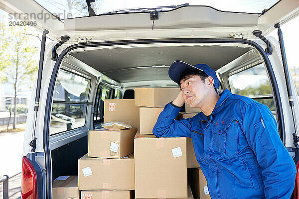 Japanese delivery man checking boxes in the car