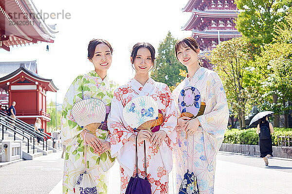 Japanese friends wearing yukata visiting traditional temple in Tokyo