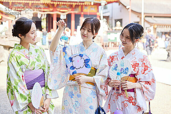 Japanese friends wearing yukata visiting traditional temple in Tokyo