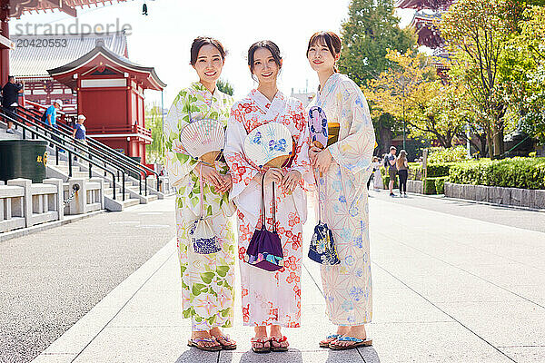 Japanese friends wearing yukata visiting traditional temple in Tokyo