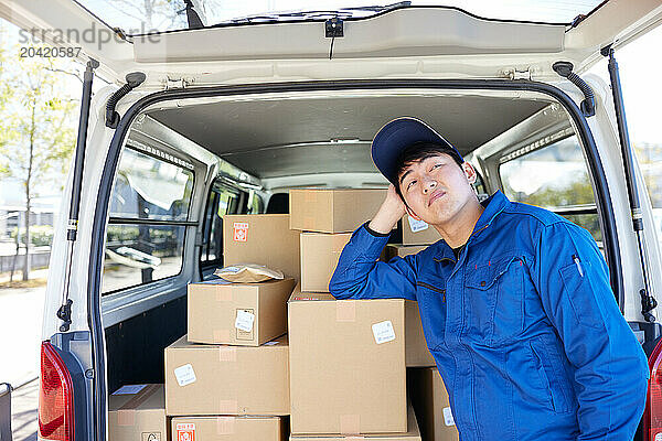 Japanese delivery man checking boxes in the car