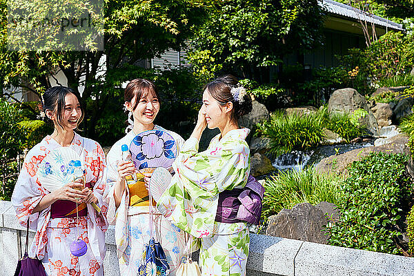 Japanese friends wearing yukata visiting traditional temple in Tokyo