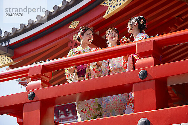 Japanese friends wearing yukata visiting traditional temple in Tokyo