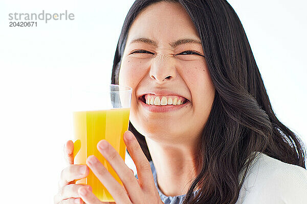 Japanese woman holding a glass of orange juice