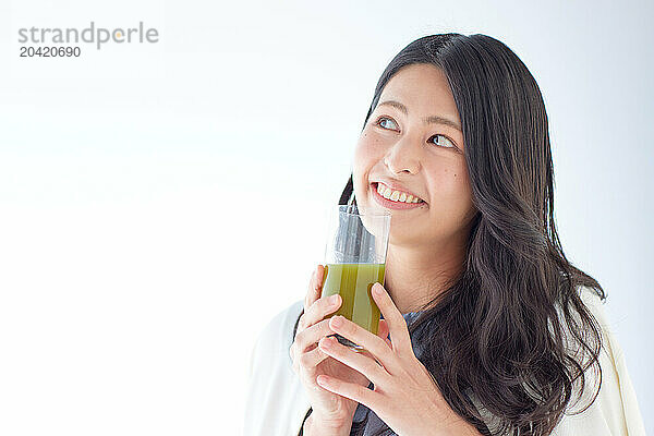 Japanese woman holding a glass of green juice