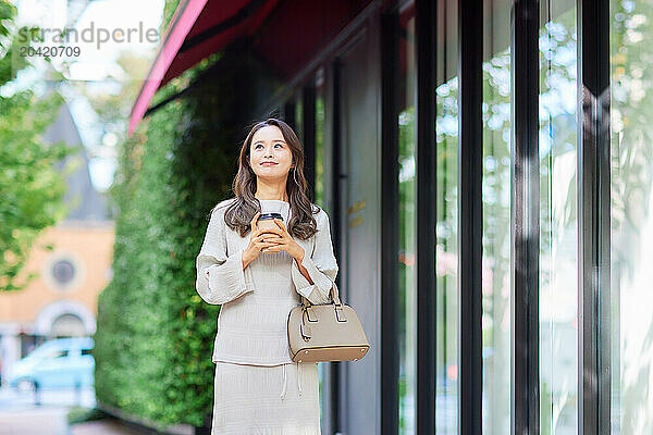 Japanese woman in a dress holding a coffee cup