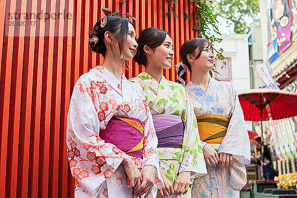 Japanese friends wearing yukata visiting traditional area in Tokyo