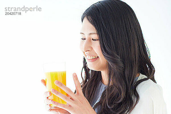 Japanese woman holding a glass of orange juice