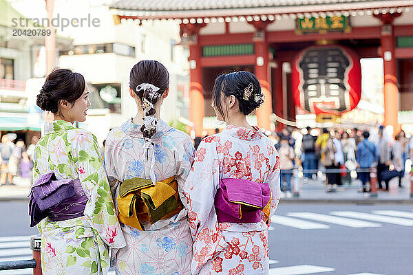 Japanese friends wearing yukata visiting traditional temple in Tokyo