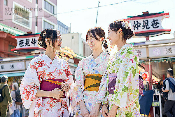 Japanese friends wearing yukata visiting traditional temple in Tokyo