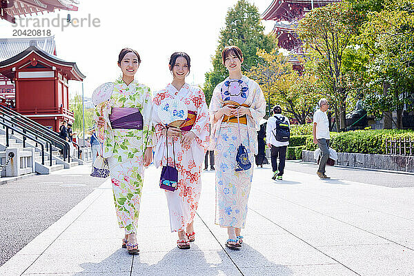 Japanese friends wearing yukata visiting traditional temple in Tokyo