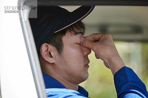 Japanese delivery man sitting in the driver seat