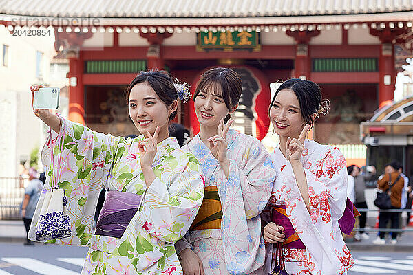 Japanese friends wearing yukata visiting traditional temple in Tokyo