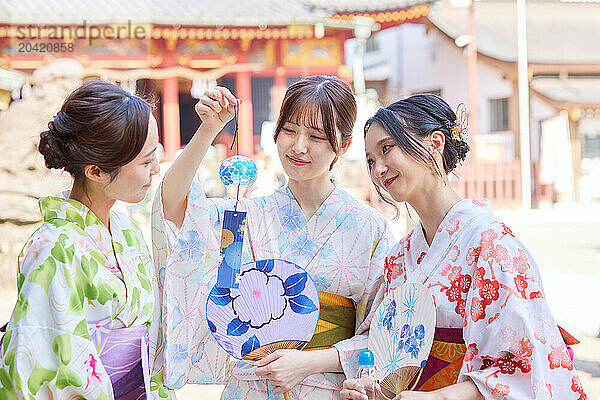 Japanese friends wearing yukata visiting traditional temple in Tokyo