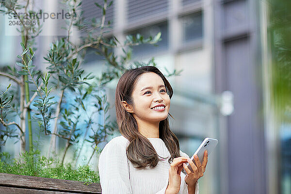 Japanese woman using her smartphone outdoors