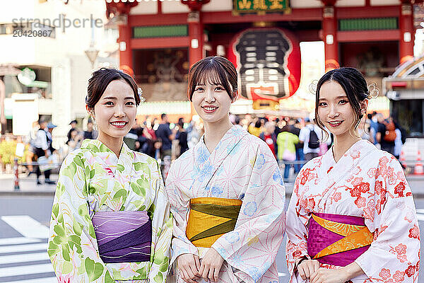 Japanese friends wearing yukata visiting traditional temple in Tokyo