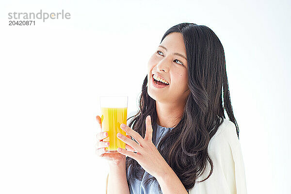 Japanese woman holding a glass of orange juice