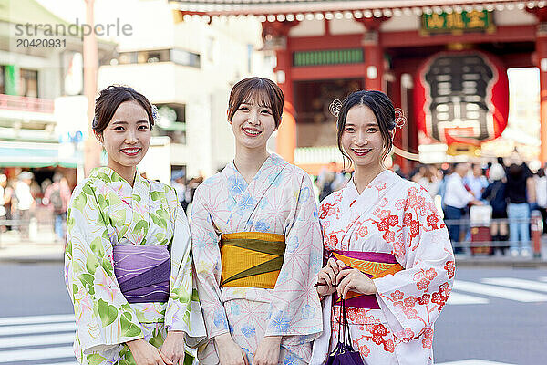 Japanese friends wearing yukata visiting traditional temple in Tokyo